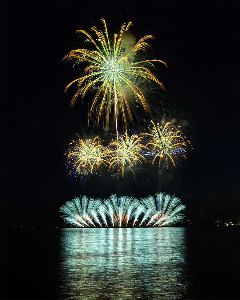 Fireworks blooming over the sea